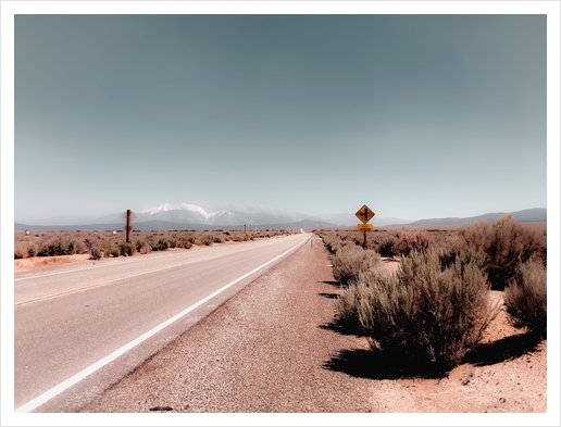 Road in the desert with blue sky and mountain view in California USA Art Print by Timmy333